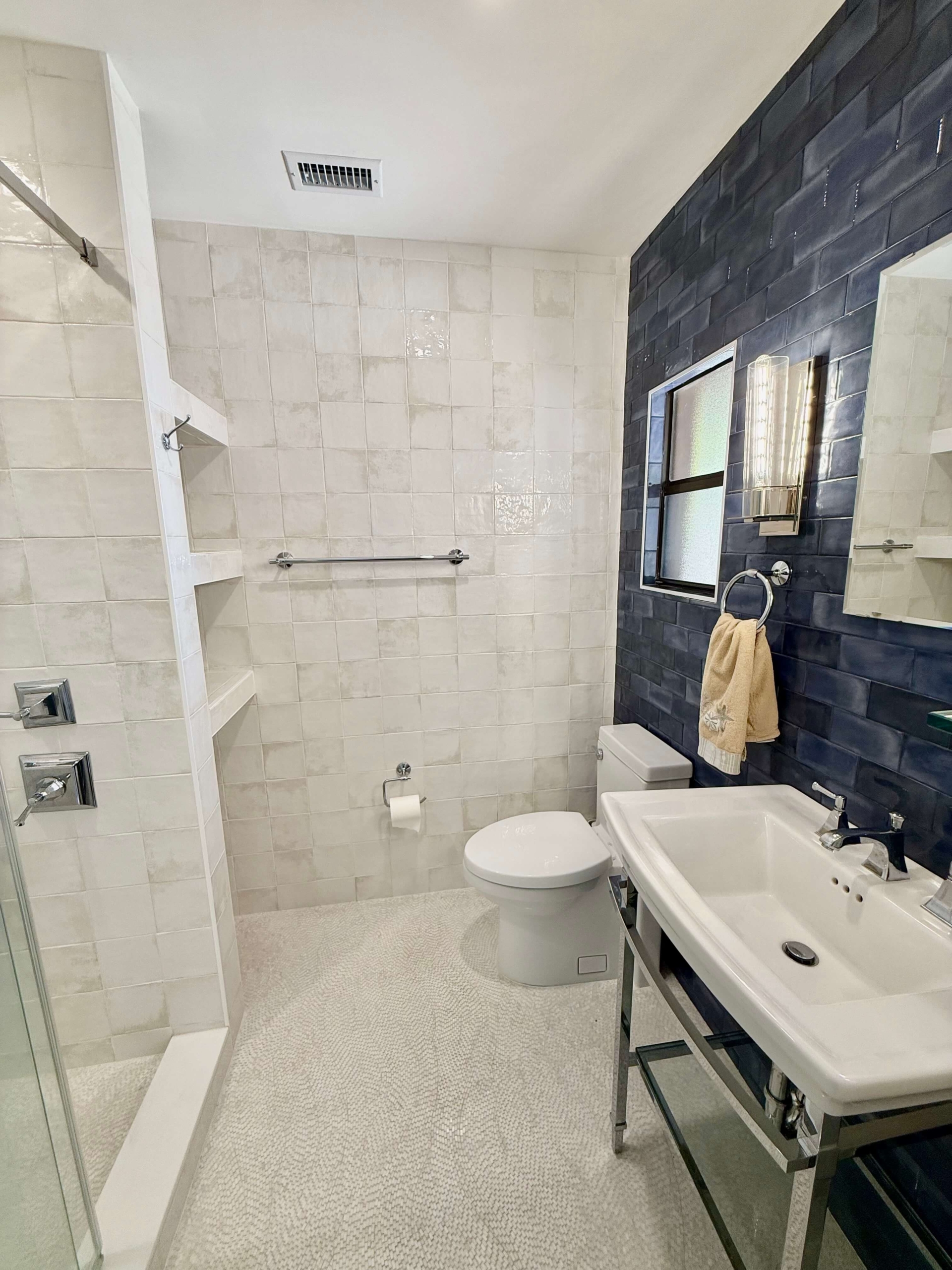 photo of bathroom with a shower and blue tile